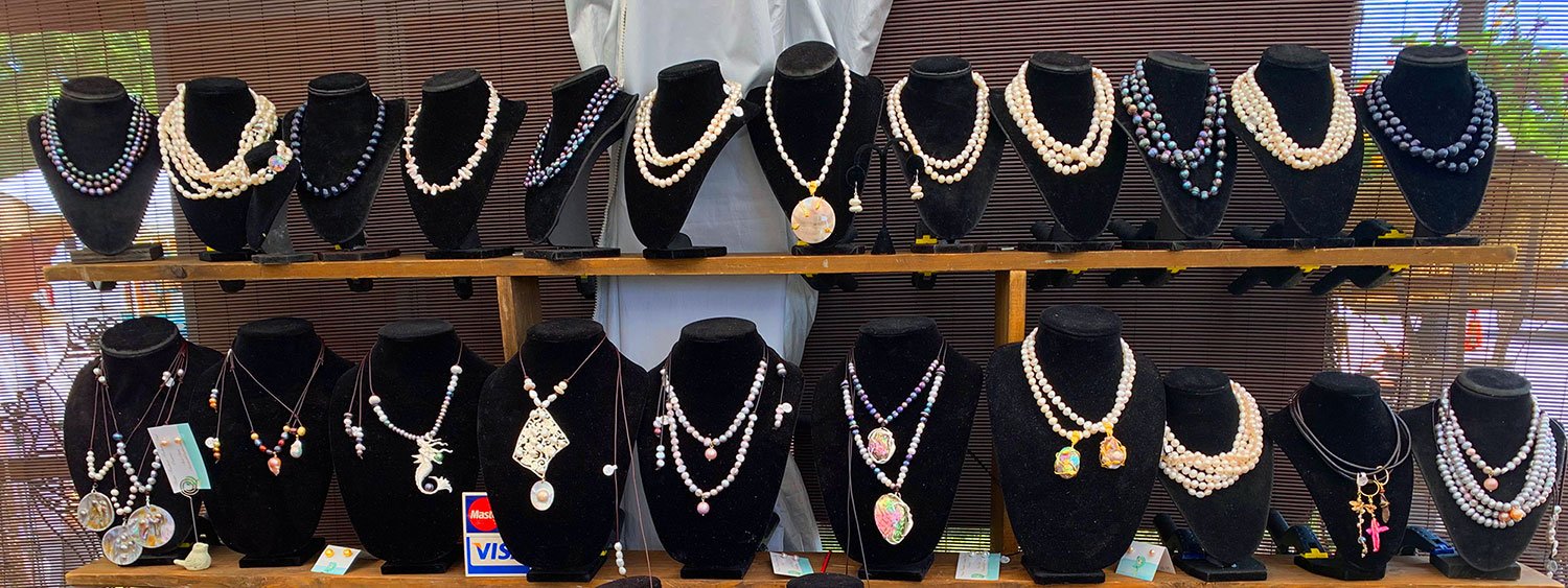 Rows of Suzie's handcrafted pearl necklaces on display at her booth