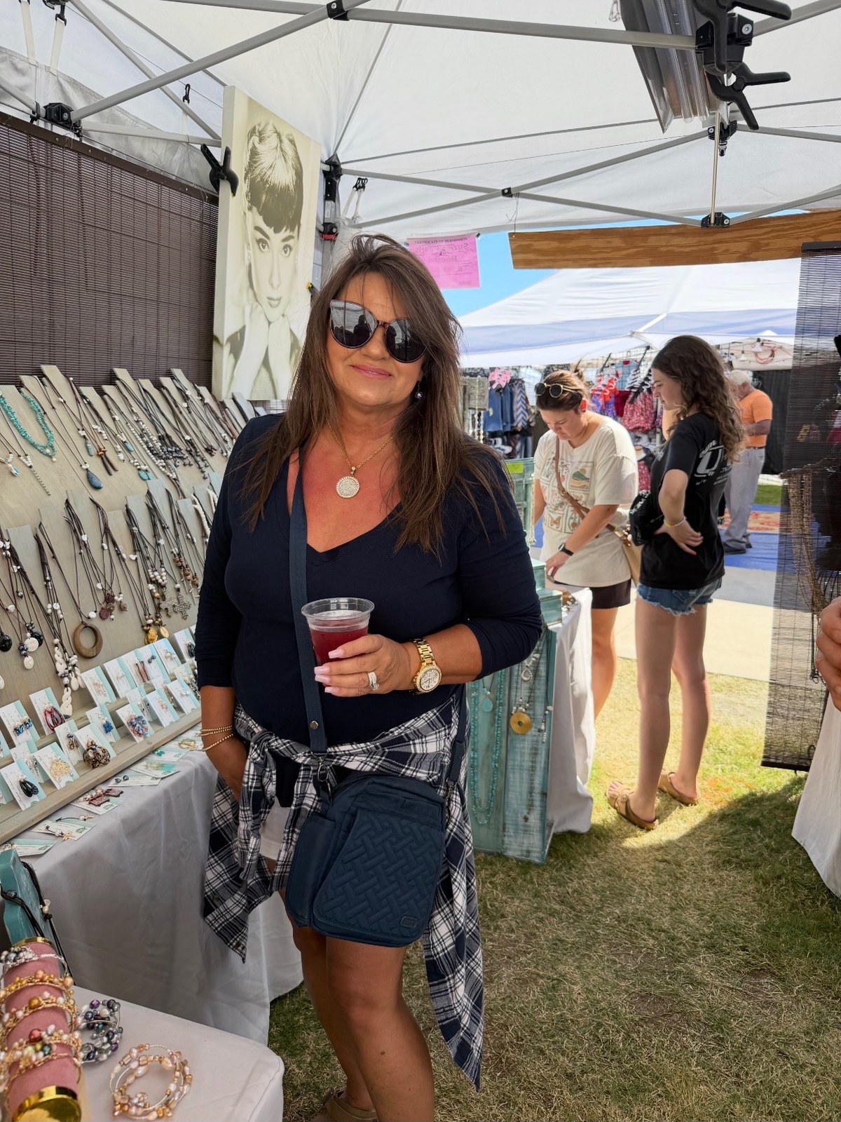 Suzie at her summer festival booth wearing one of her pendant necklaces