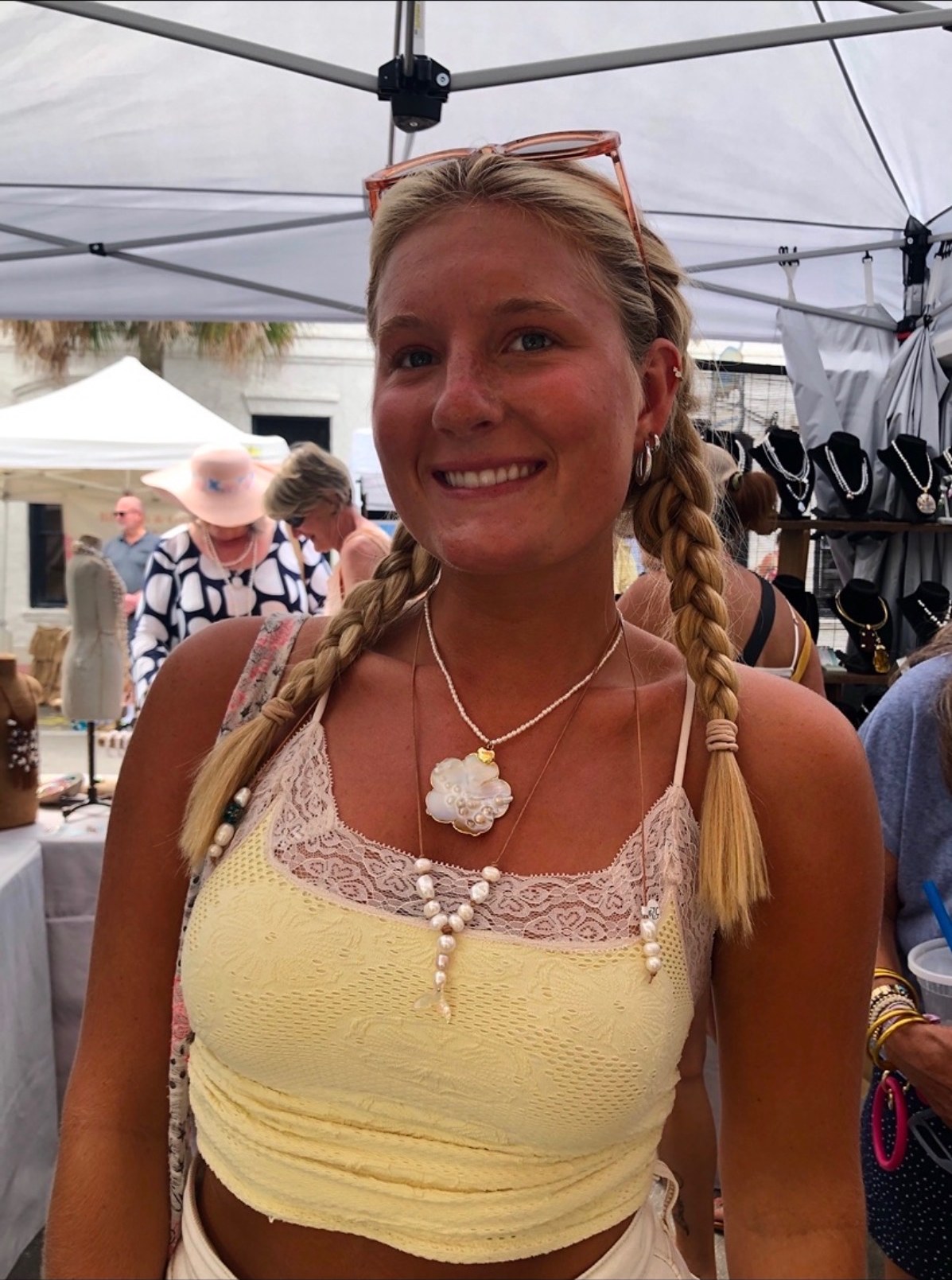 A customer wearing a shell-flower pearl pendant necklace in the booth