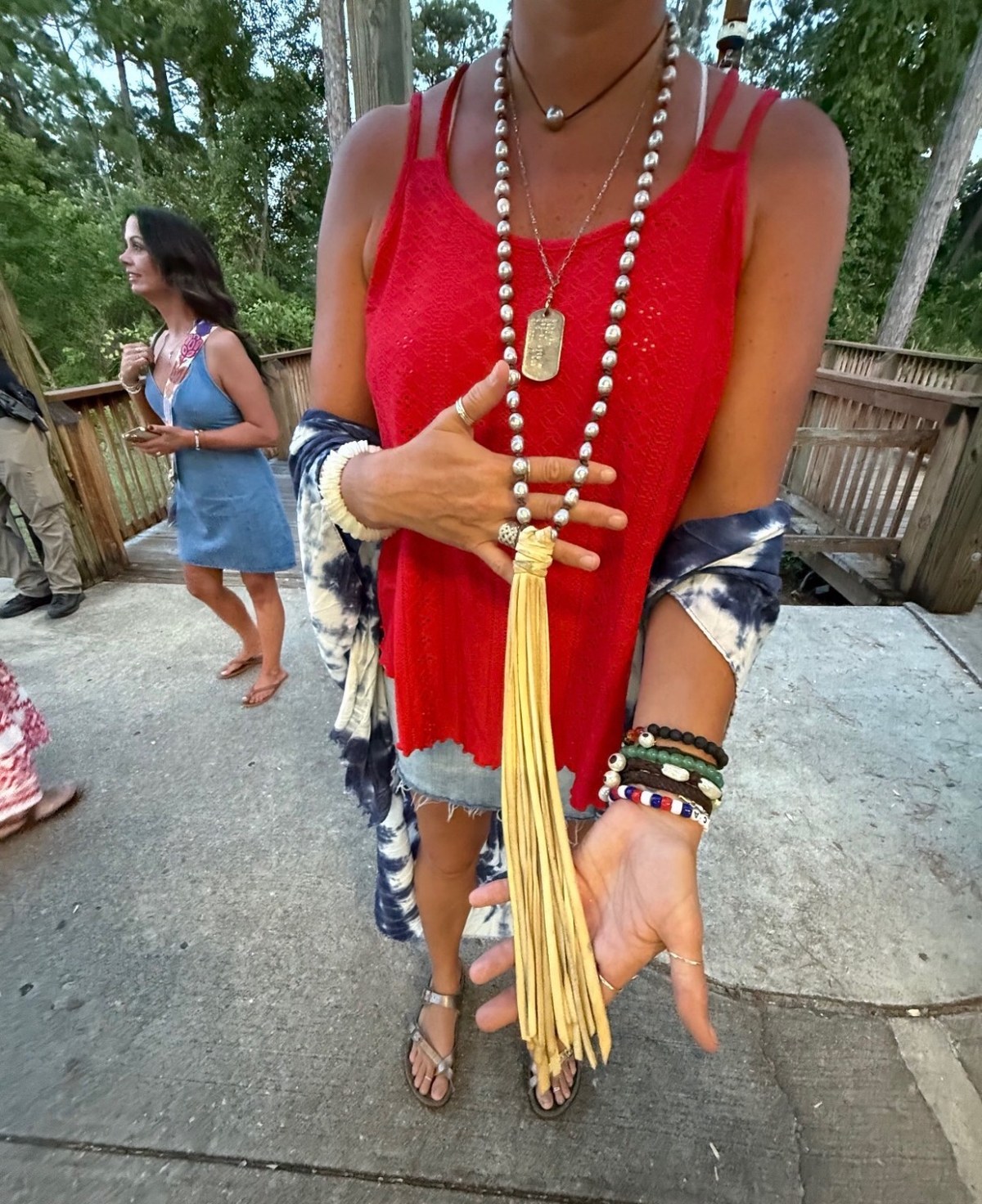 A customer wearing a long pearl and leather lariat knotted at the hip