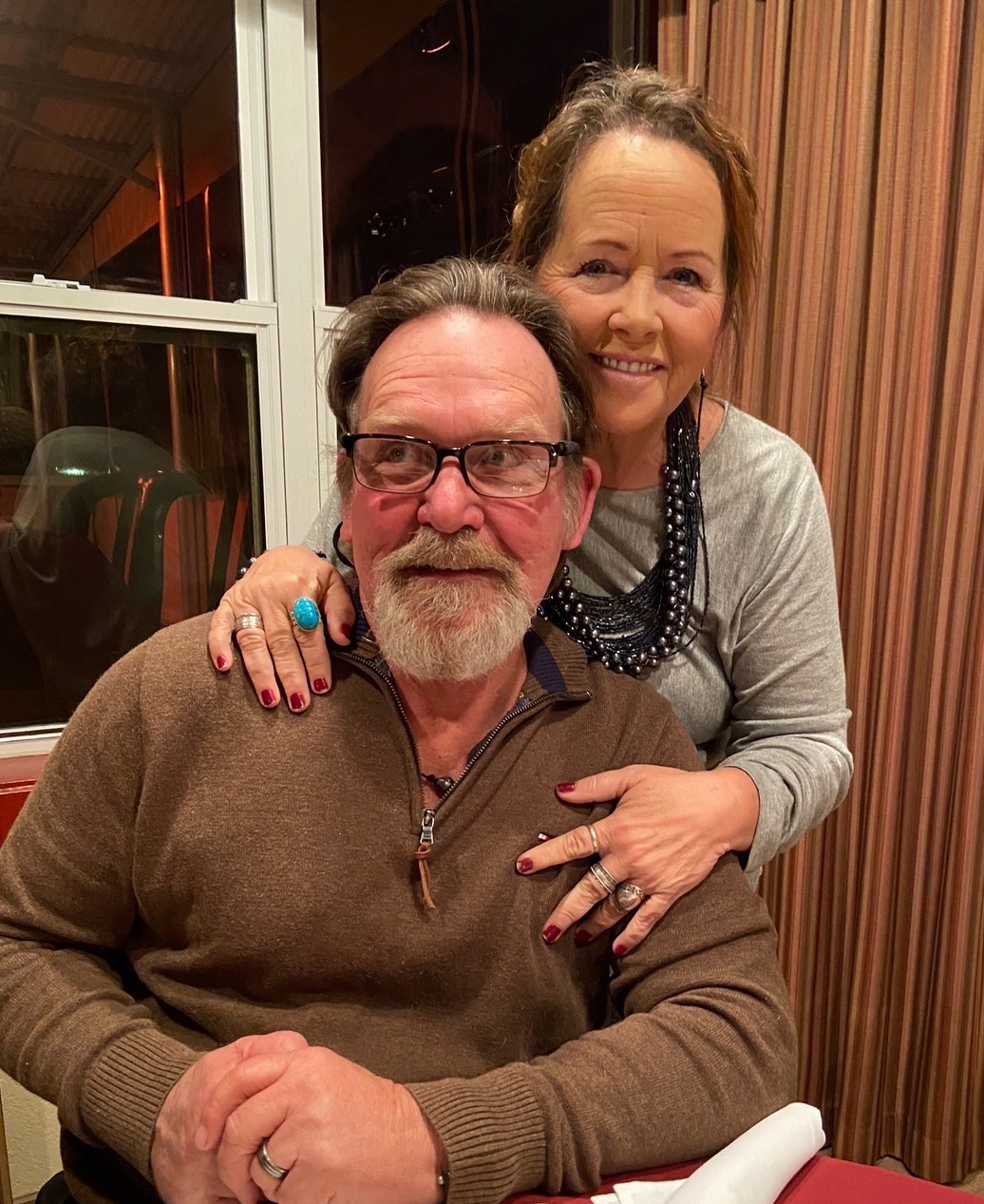 Suzie and her husband Rick together, Suzie wearing one of her necklaces