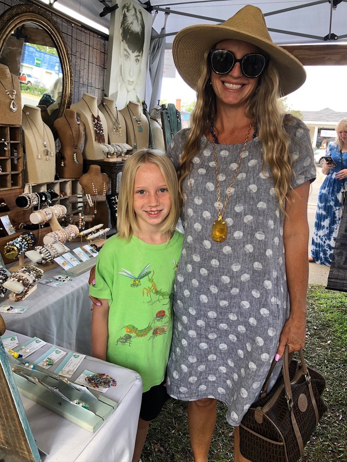 A mother and daughter picking out jewelry together at the booth